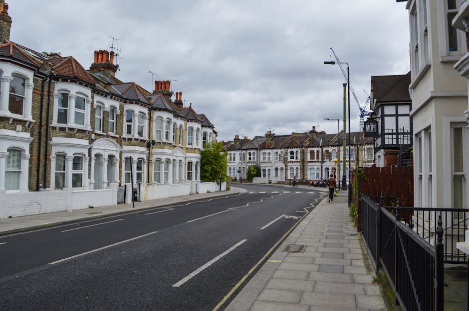 A row of Victorian-style terraced houses with ornate ironwork balconies and decorative brickwork, located along a paved street in Finsbury Park. The houses feature large bay windows, some with white f